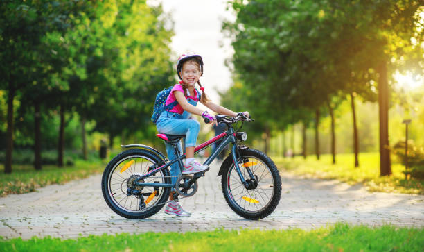 happy cheerful child girl riding a bike in Park in the nature